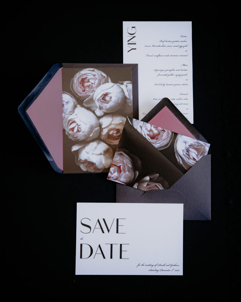 Bold and black origami wedding invitations with a purple envelope liner and matching save the date card.