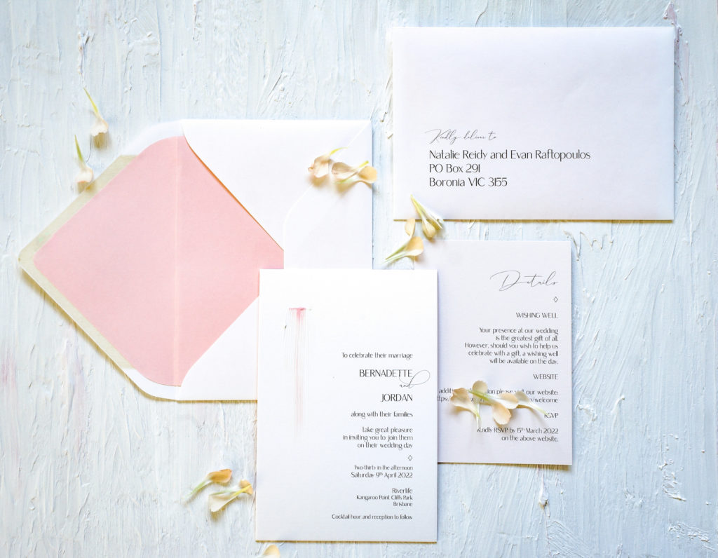 Pale pink and white wedding invitation suite with hand-painted pink and white detailing.