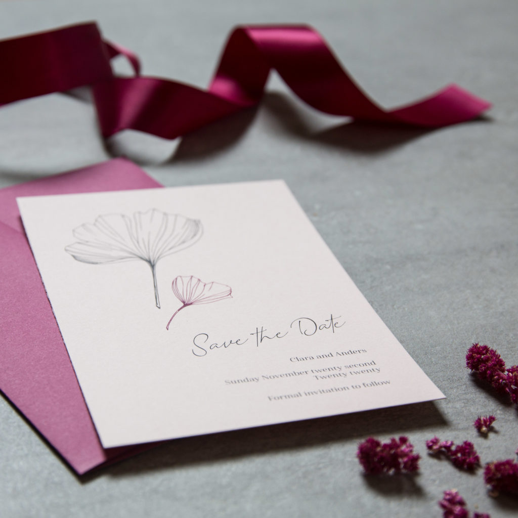 Save the date card with cursive font and ginkgo leaf design and plum coloured envelope.