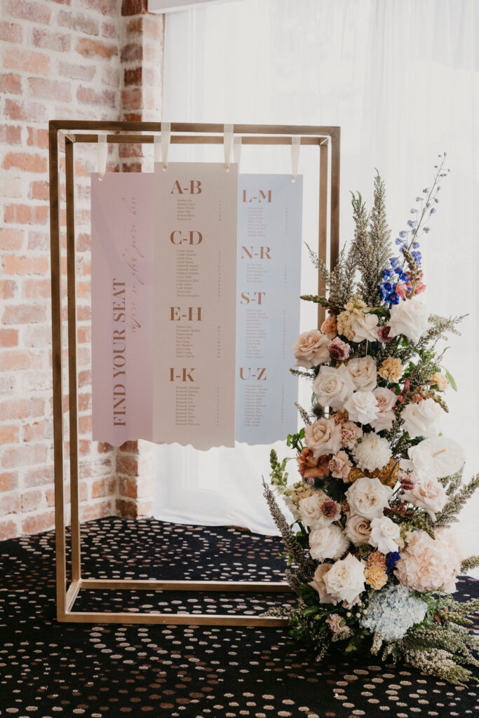 A three-piece wedding table seating chart with names in alphabetical order.