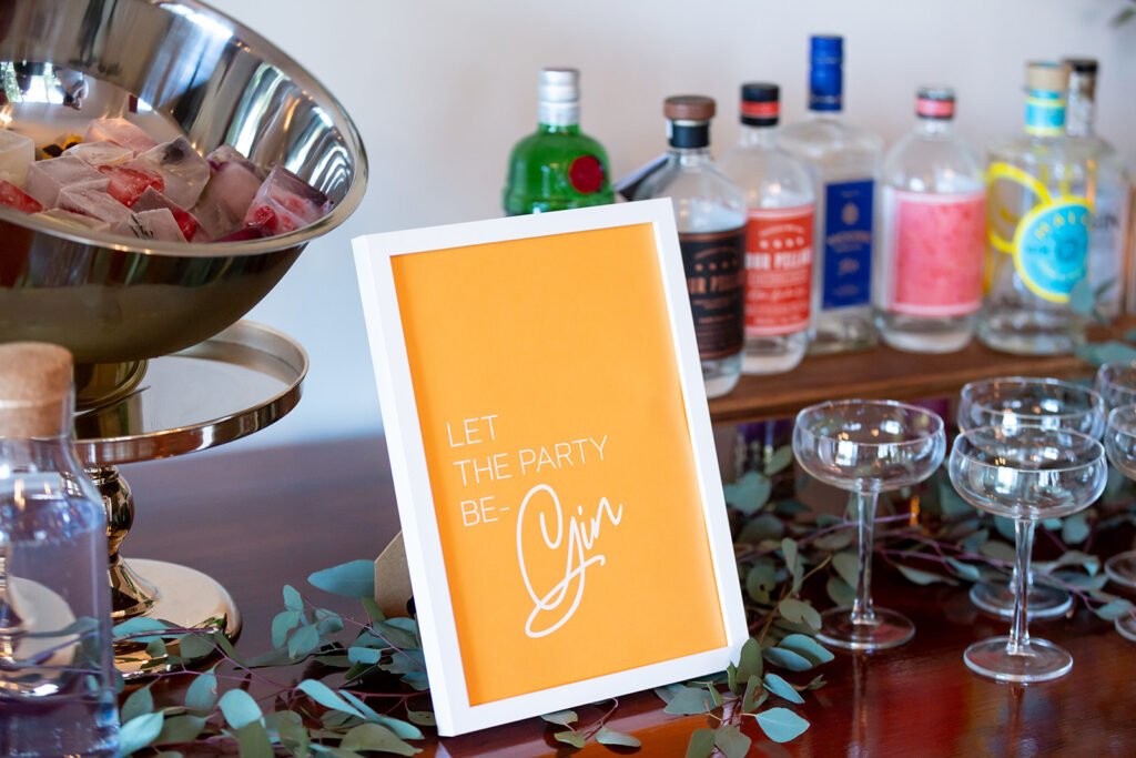 Wedding signage for a gin bar with the text "Let the party be-gin"