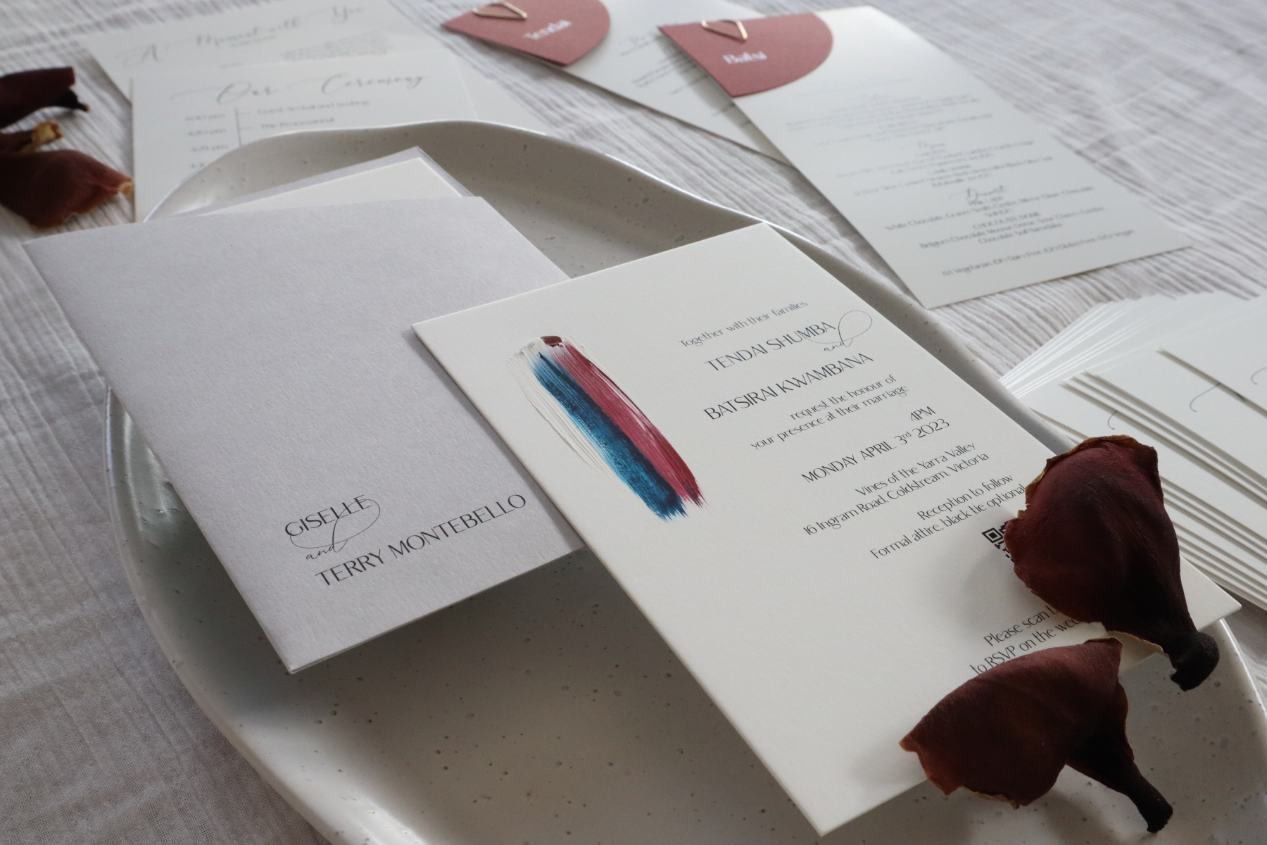 Ivory wedding invitations with burgundy and navy blue paint.
