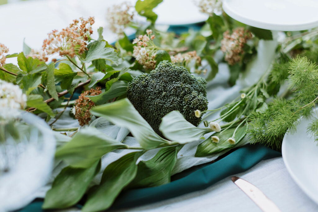Green wedding reception styling with foliage and broccoli.