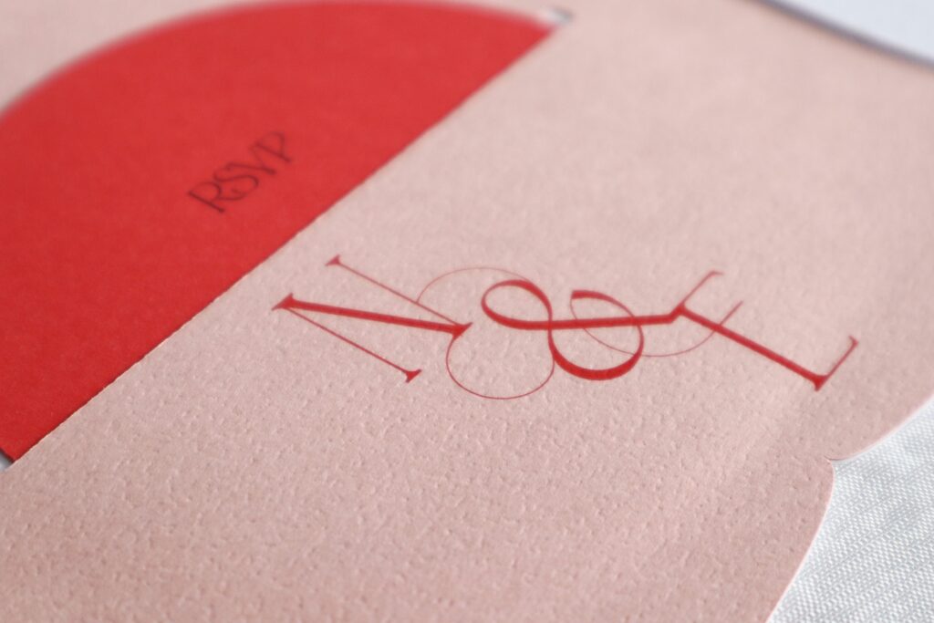 Couples monogram on a wedding invitation with a round RSVP card.