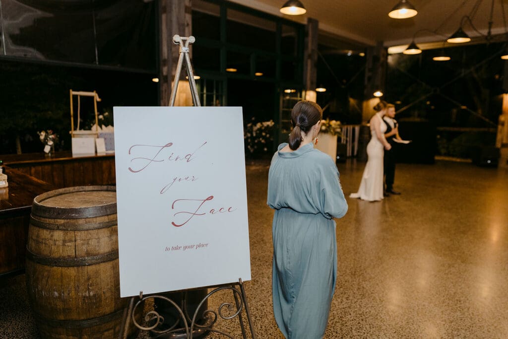 A large white sign that says "Find Your Face" at a wedding reception